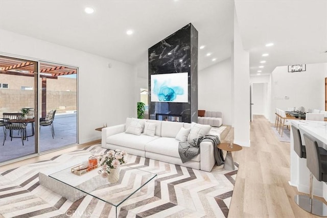 living room with light wood-type flooring, baseboards, vaulted ceiling, and recessed lighting