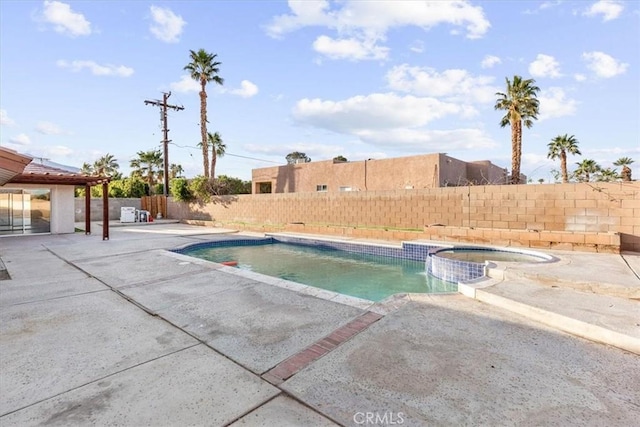 view of swimming pool featuring a patio area, a fenced backyard, and a pool with connected hot tub