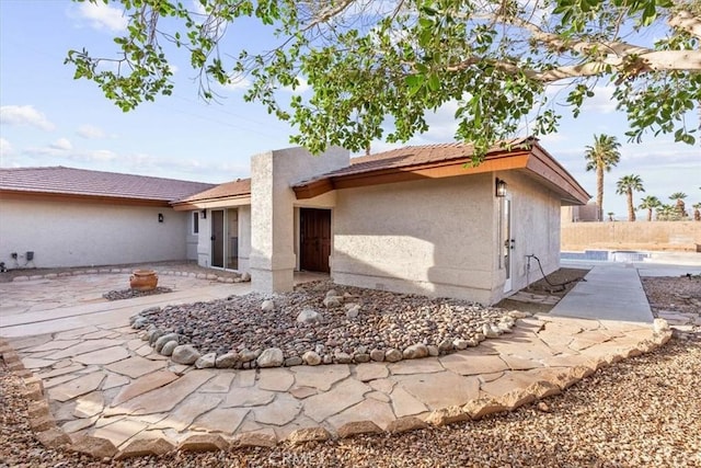 back of property featuring stucco siding and a patio