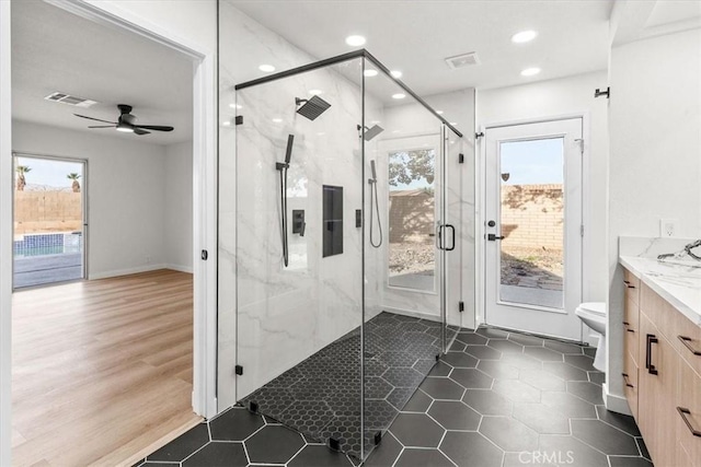 bathroom featuring a marble finish shower, toilet, ceiling fan, vanity, and recessed lighting