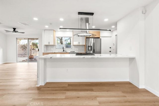 3190 E Vincentia Rd, Palm Springs, CA 92262 - kitchen with stainless steel appliances, white cabinets, recessed lighting, light wood finished floors, and backsplash