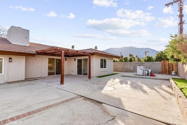 back of house featuring a patio area, a fenced backyard, a tile roof, and stucco siding