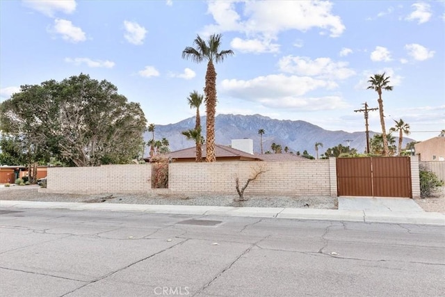 exterior space featuring a fenced front yard, a gate, and a mountain view