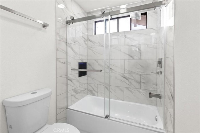 full bathroom with combined bath / shower with glass door and toilet