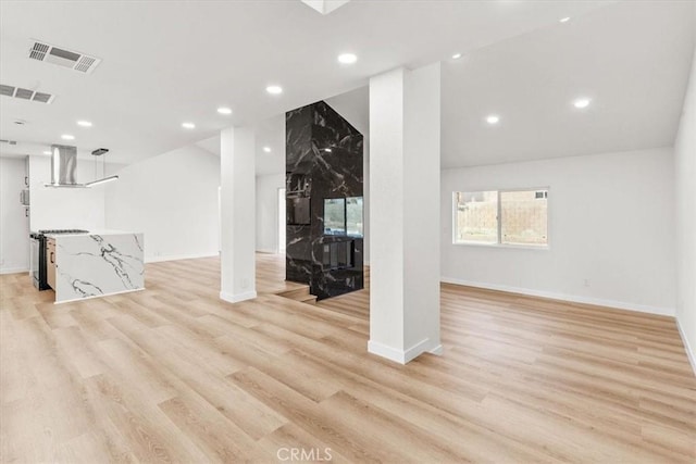 unfurnished living room with light wood-type flooring, visible vents, baseboards, and recessed lighting