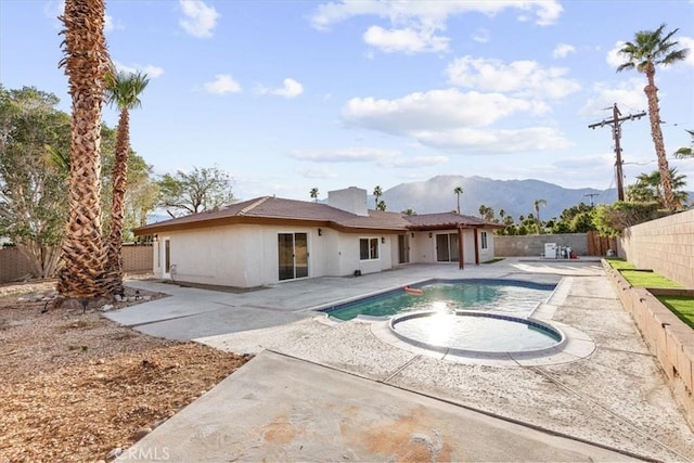 back of property featuring a mountain view, a fenced backyard, a patio, and stucco siding