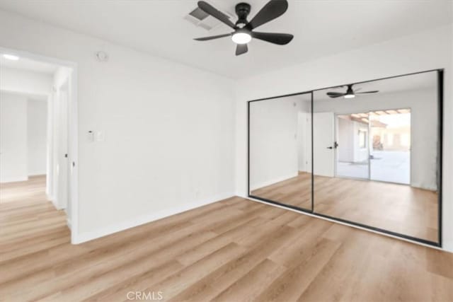 unfurnished bedroom featuring ceiling fan, a closet, wood finished floors, and baseboards