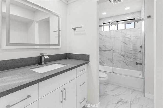 full bathroom featuring visible vents, toilet, marble finish floor, combined bath / shower with glass door, and vanity