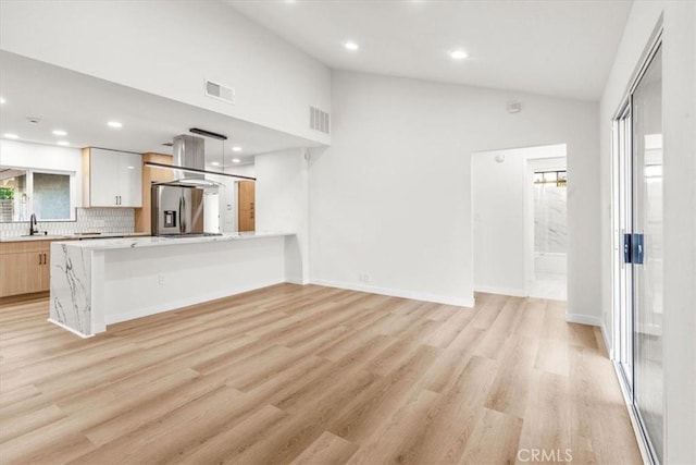 3190 E Vincentia Rd, Palm Springs, CA 92262 - unfurnished living room featuring vaulted ceiling, light wood-type flooring, recessed lighting, and a sink