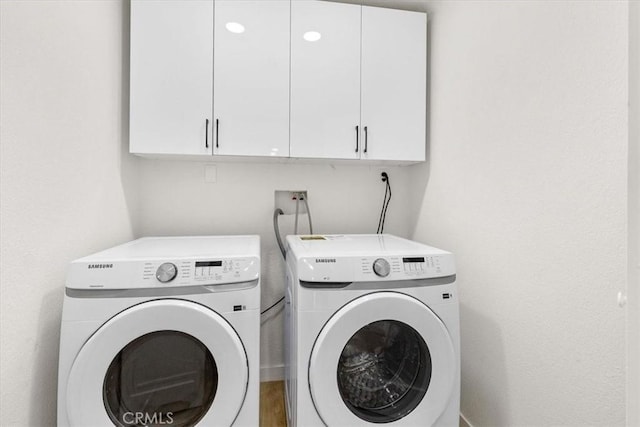 washroom featuring washer and dryer and cabinet space