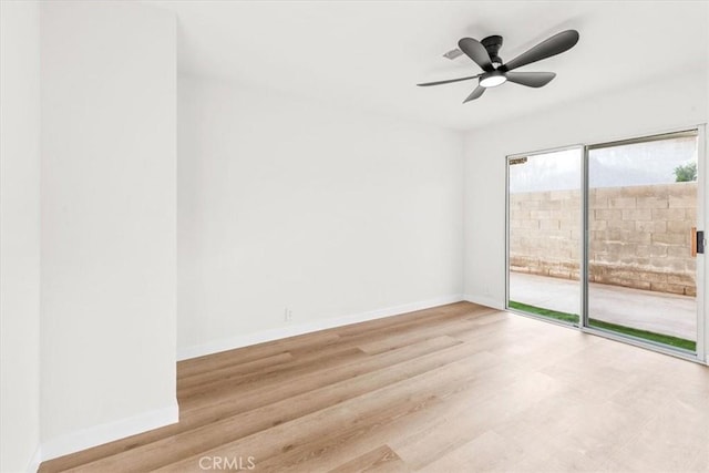 unfurnished room featuring a ceiling fan, baseboards, and wood finished floors