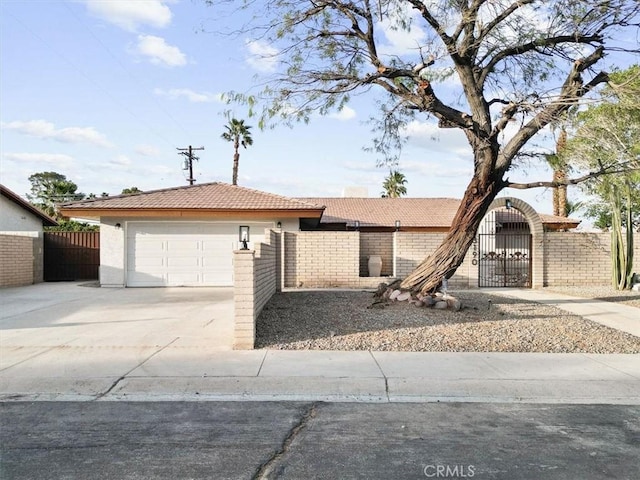 3190 E Vincentia Rd, Palm Springs, CA 92262 - single story home with a fenced front yard, a garage, concrete driveway, a tiled roof, and stucco siding