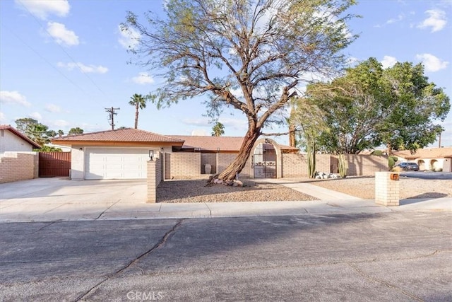 view of front of home featuring a garage, fence, and concrete driveway