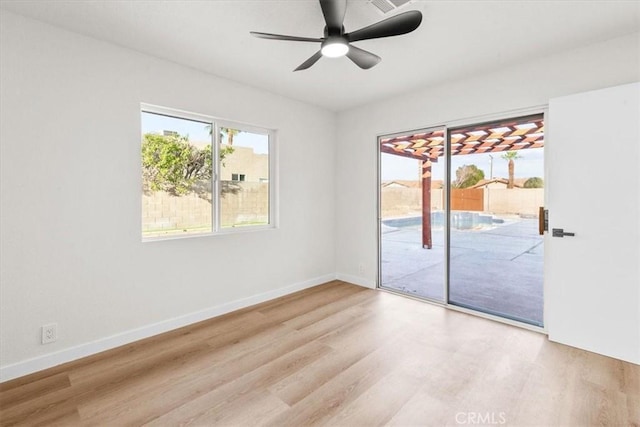 spare room with ceiling fan, baseboards, and wood finished floors