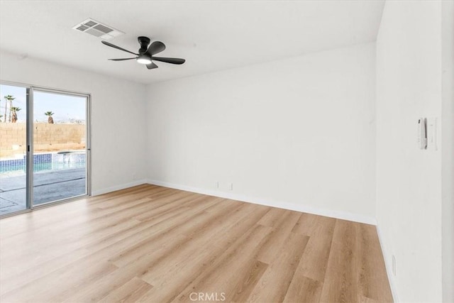 empty room featuring ceiling fan, baseboards, visible vents, and light wood-style floors