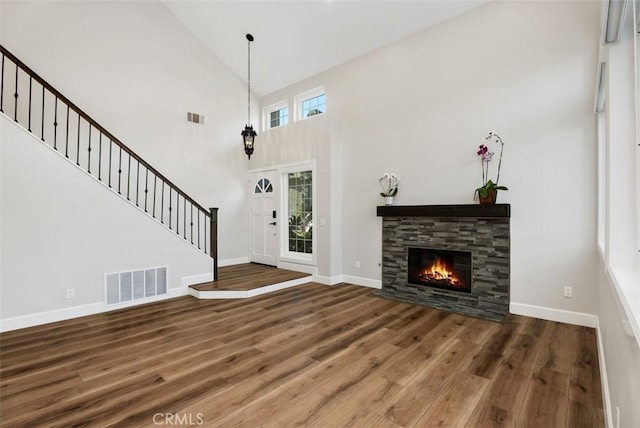 foyer featuring visible vents, stairway, baseboards, and wood finished floors