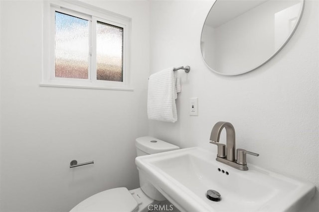 bathroom with toilet and a sink