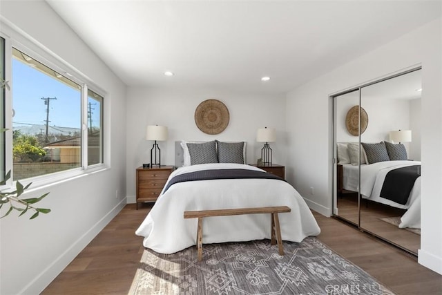 bedroom featuring a closet, recessed lighting, wood finished floors, and baseboards