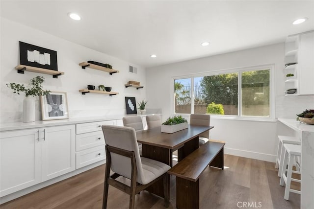 dining room featuring baseboards, visible vents, dark wood finished floors, and recessed lighting