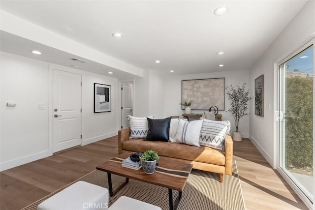 living room featuring light wood-style floors, baseboards, and recessed lighting