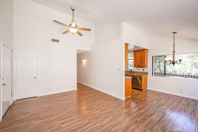 unfurnished living room with baseboards, visible vents, wood finished floors, and ceiling fan with notable chandelier