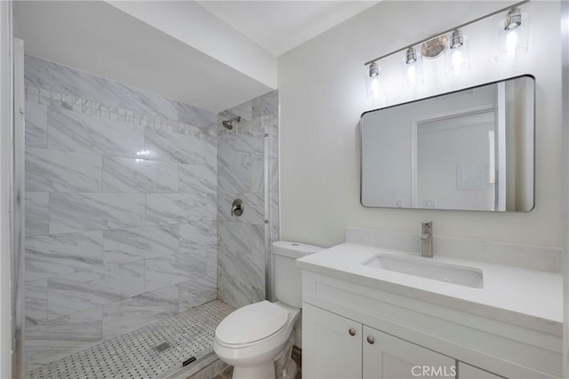 full bathroom with toilet, a tile shower, and vanity