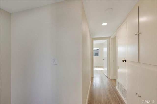 hallway featuring baseboards, recessed lighting, visible vents, and light wood-style floors