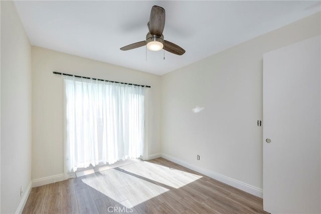 spare room with a ceiling fan, baseboards, and wood finished floors