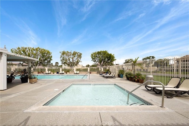 community pool with fence and a patio