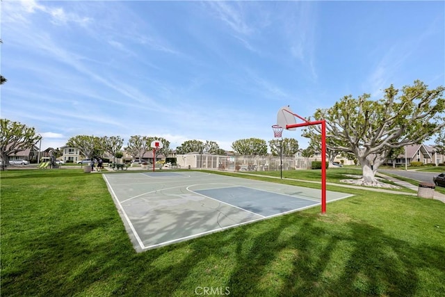 view of basketball court with a yard, fence, and community basketball court