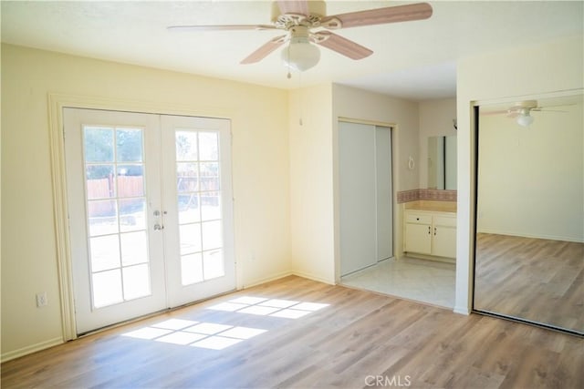 doorway featuring light wood-style floors, ceiling fan, baseboards, and french doors