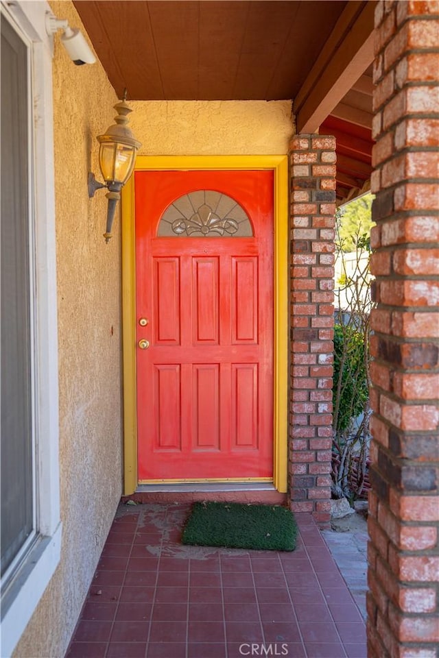 entrance to property with brick siding and stucco siding