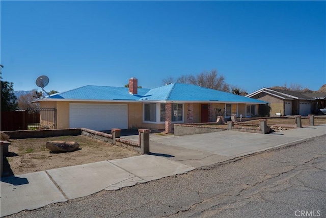 ranch-style house with a garage, a chimney, fence, and driveway