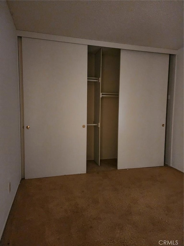 unfurnished bedroom featuring a closet and light colored carpet