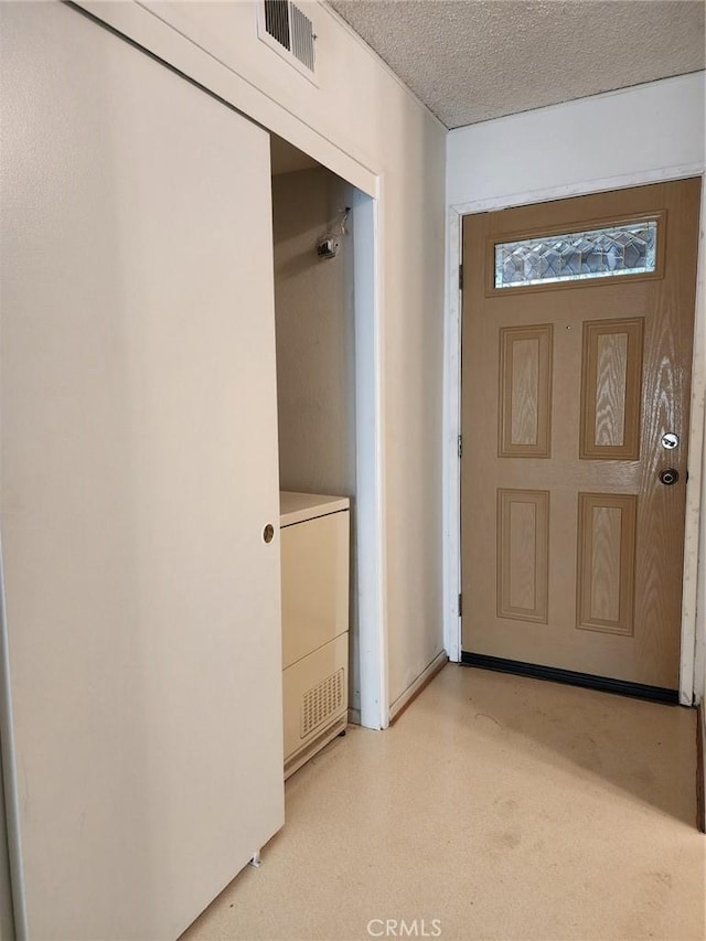 interior space with a textured ceiling, washer / clothes dryer, and visible vents