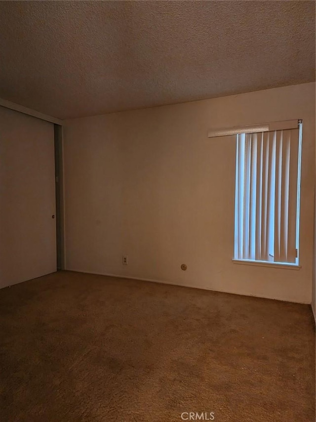 spare room with carpet floors and a textured ceiling