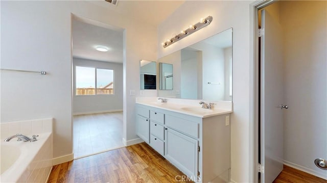 12912 Amador St, Victorville, CA 92392 - bathroom featuring a bath, a sink, double vanity, and wood finished floors