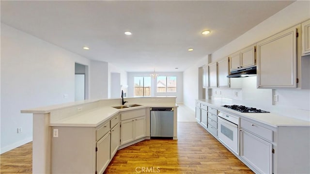 12912 Amador St, Victorville, CA 92392 - kitchen with a sink, black gas cooktop, under cabinet range hood, stainless steel dishwasher, and white oven