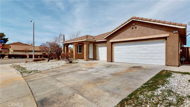 12912 Amador St, Victorville, CA 92392 - ranch-style home featuring a tile roof, concrete driveway, a garage, and stucco siding