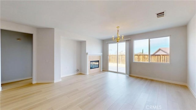12912 Amador St, Victorville, CA 92392 - unfurnished living room with visible vents, baseboards, an inviting chandelier, and light wood-style flooring