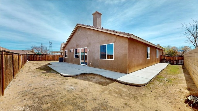 12912 Amador St, Victorville, CA 92392 - rear view of house featuring a patio area, stucco siding, a chimney, and a fenced backyard