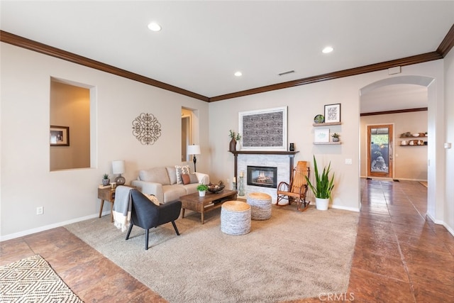 living room with arched walkways, a glass covered fireplace, baseboards, and recessed lighting