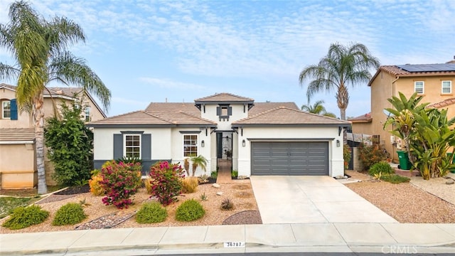 view of front facade featuring a garage, concrete driveway, and stucco siding