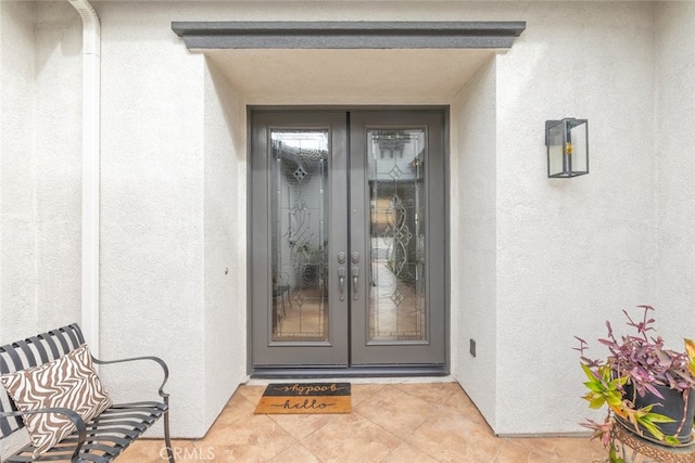 doorway to property featuring french doors and stucco siding