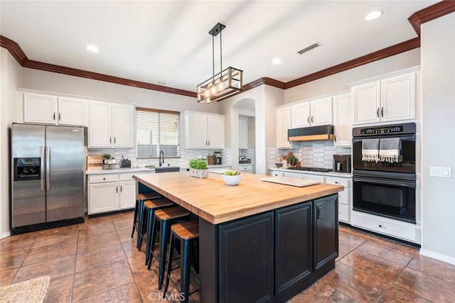 kitchen featuring dobule oven black, white cabinets, a kitchen island, under cabinet range hood, and stainless steel refrigerator with ice dispenser