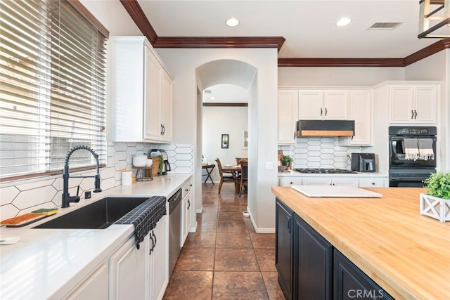 kitchen featuring visible vents, white cabinets, under cabinet range hood, gas cooktop, and a sink