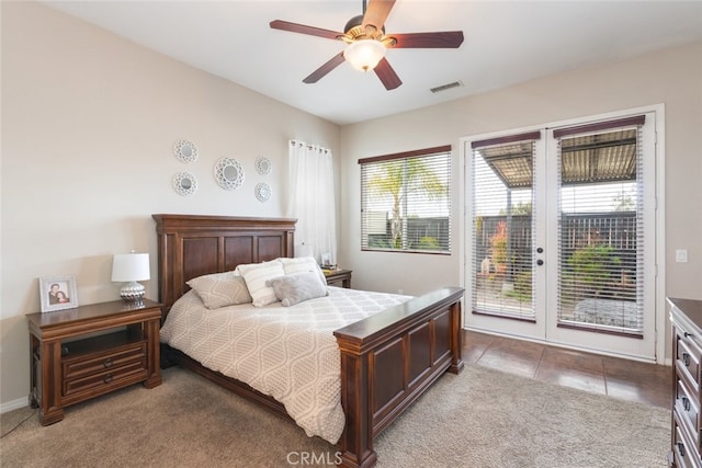 carpeted bedroom with access to exterior, visible vents, ceiling fan, and tile patterned floors