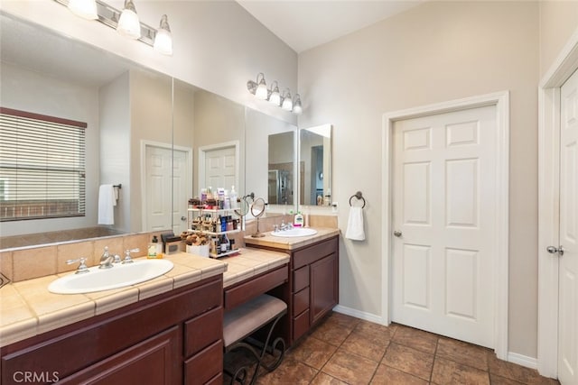 full bath with a sink, baseboards, and double vanity