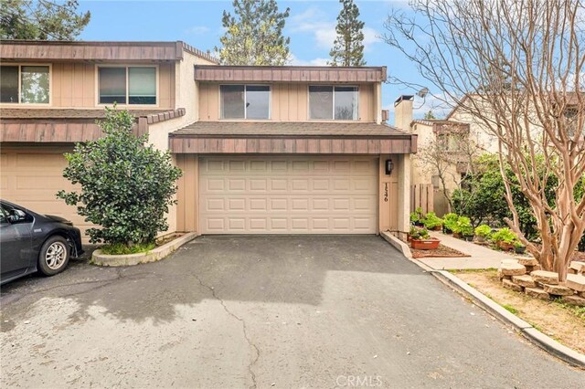 view of property featuring an attached garage and aphalt driveway