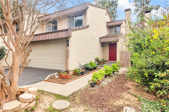 view of front of property with driveway, an attached garage, and stucco siding